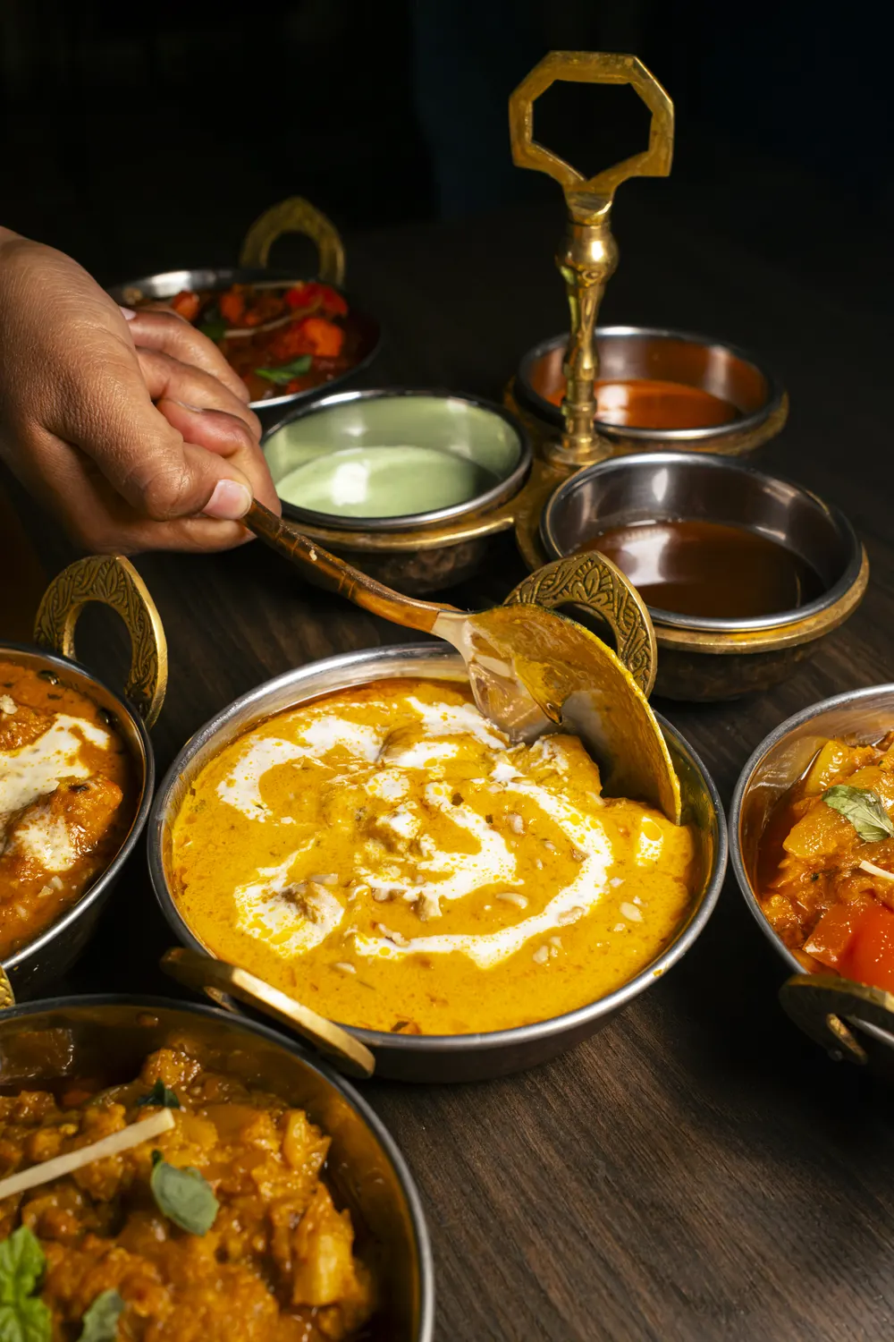 Curry servito con le salse nel portasalse in ottone
